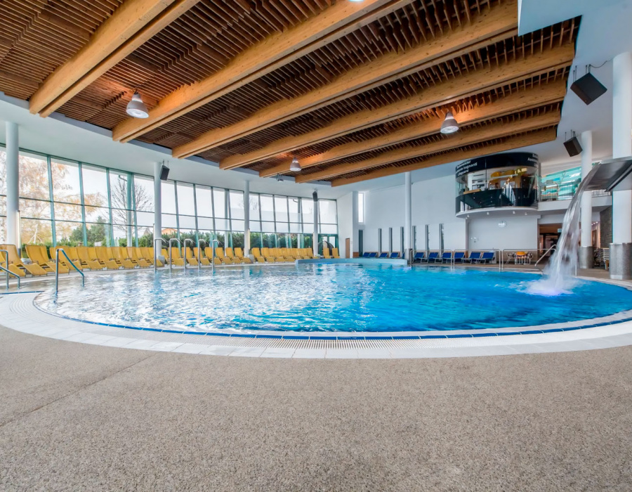 Isoplam draining resin stone floor around indoor pool with water cascade